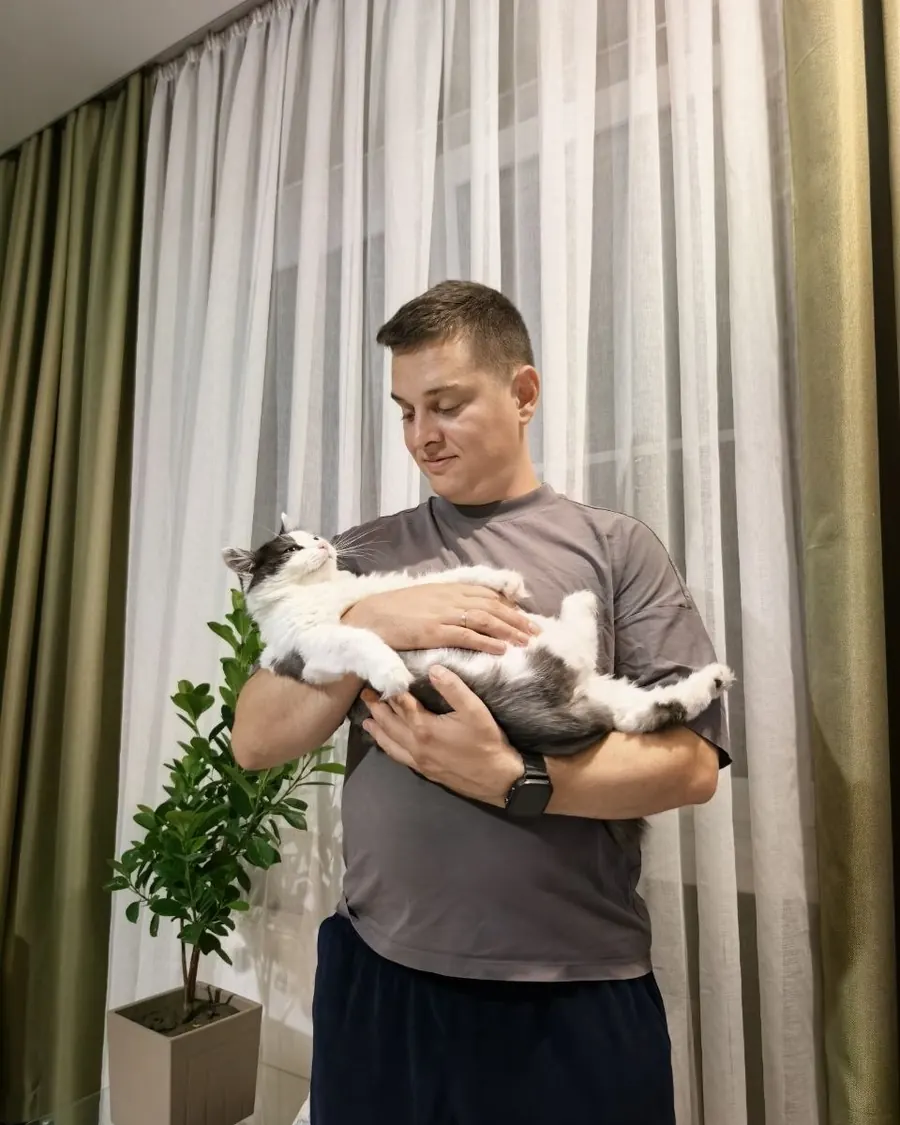 Лев держит на руках кошку Симу